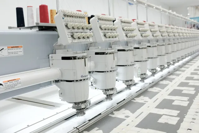 Long multi-head embroidery machine seen at an angle