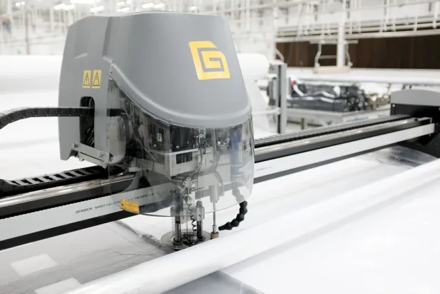 Automatic cutting head moving over a layered fabric table
