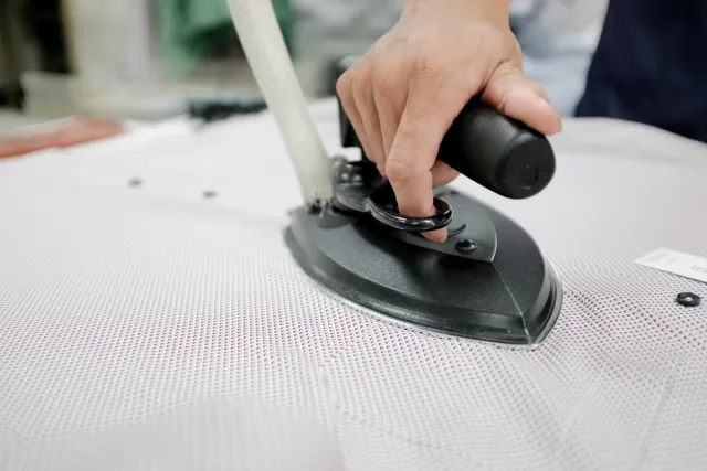 Industrial iron pressing a shirt